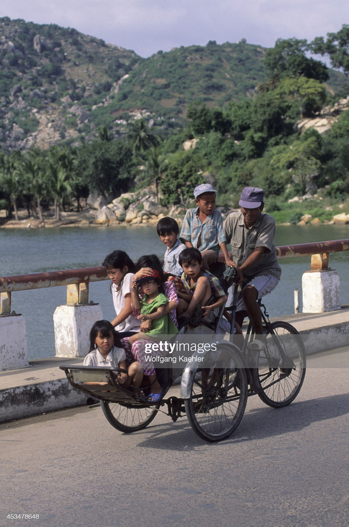 Những đứa trẻ ngồi chật kín chiếc xích lô trên cầu Xóm Bóng.