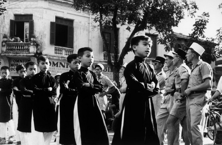 Học sinh Hà Nội mặc áo dài, khoanh tay khi đi qua đường, 23/5/1954.