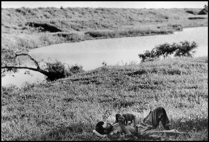 Một người lính Pháp thư giãn với chú chó của mình bên bờ sông ở Nam Định, 24/5/1954.