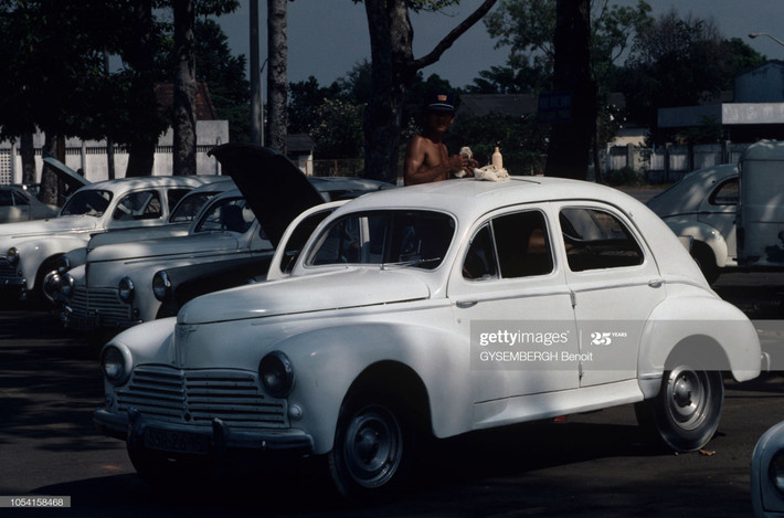 Người tài xế lau chùi chiếc xe Renault 4CV, TP HCM.