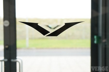 Logo của điện thoại Vertu được in trên cửa ra vào. Ban đầu logo của vertu được thiết kế theo dạng 2 cánh tay đang dang ra, tuy nhiên sau đó logo này đã thay đổi do được nhận xét giống với logo hãng xe Mazda của Nhật Bản.