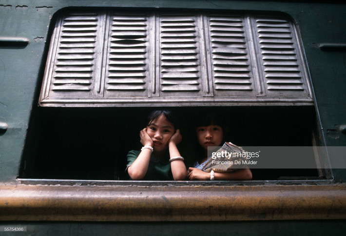 Hai bé gái bên cửa sổ một toa tàu ở ga Hà Nội, 1989.