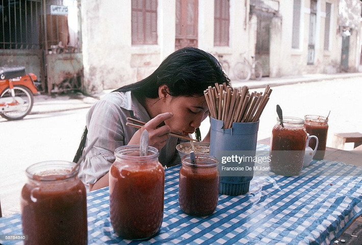 Cô gái thưởng thức bữa sáng trên vỉa hè Hà Nội, 1989.