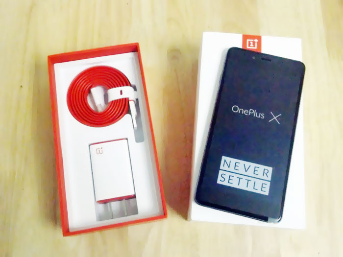 Vỏ hộp điện thoại One Plus X nổi bật với hai màu trắng và đỏ. Đi kèm máy là phụ kiện dây sạc dẹt chống rối và củ sạc cũng được phối hai màu trắng đỏ bắt mắt.