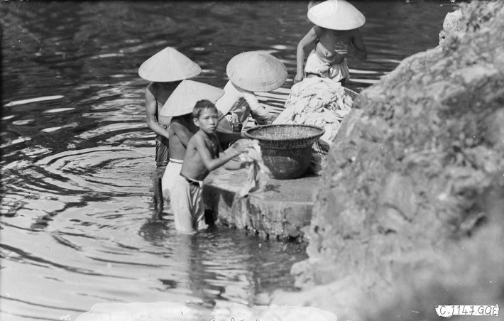 Người dân tắm giặt dưới sông.