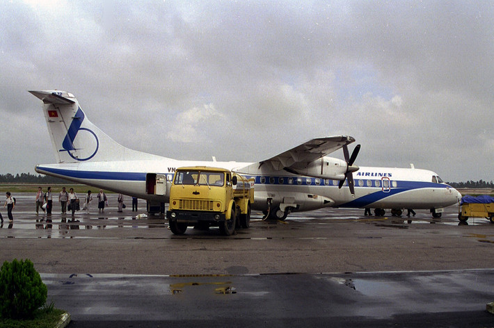 Hành khách đi bộ từ máy bay vào nhà ga Nội Bài trong khi chiếc xe bồn đang tiếp xăng cho máy bay. Ảnh: Ian Lynas Flickr.