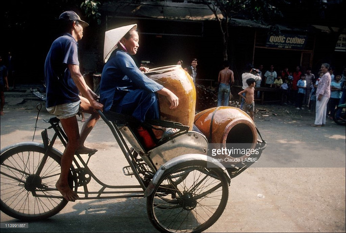 Chuyến xích lô chở cụ bà và những vại nước lớn, TP. HCM năm 1991. Ảnh: Jean-Claude Labbe/Getty Images