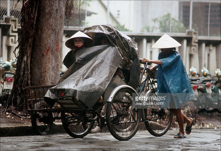 Người lái xích lô hành nghề dưới mưa.