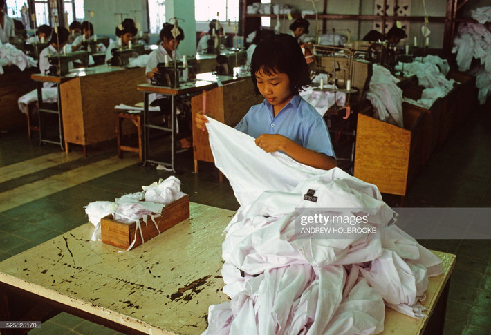 Thợ may nhỏ tuổi làm việc trong một xí nghiệp may mặc xuất khẩu.