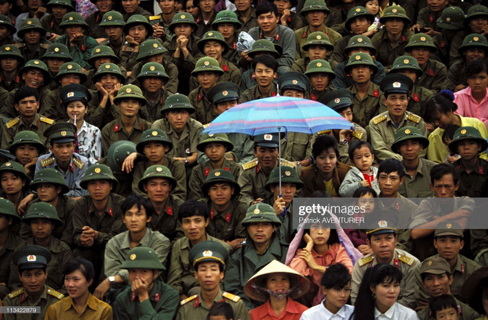 Các quân nhân trẻ và người dân trên khán đài của sân vận động.