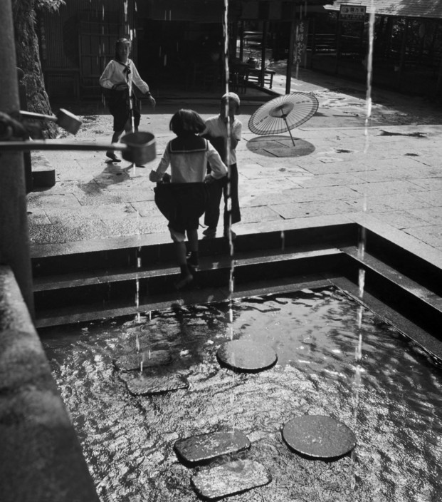 Nước băng tan từ mái đền Kiyomizu chảy xuống ao nước thanh tẩy ở sân đền. Ảnh: Werner Bischof.