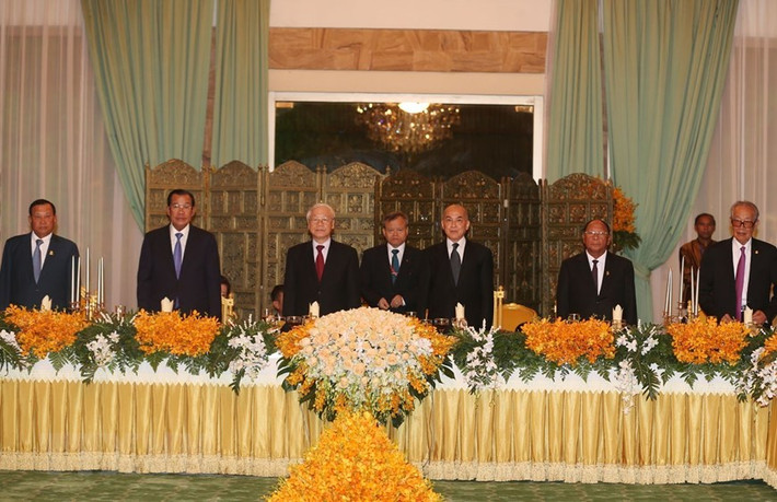 Quốc vương Campuchia Norodom Sihamoni và Tổng Bí thư, Chủ tịch nước Nguyễn Phú Trọng cùng các đại biểu thực hiện nghi lễ chào cờ. (Ảnh: Trí Dũng/TTXVN)