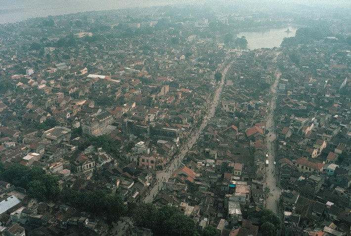 Trung tâm Hà Nội năm 1989 nhìn từ trên cao, với hồ Hoàn Kiếm ở góc trên bên phải. Bên trái là đường Hàng Ngang – Hàng Đào, bên phải là Lương Văn Can. Giai đoạn này quanh hồ chưa có bóng dáng các tòa nhà cao tầng. Ảnh: David Alan Harvey.