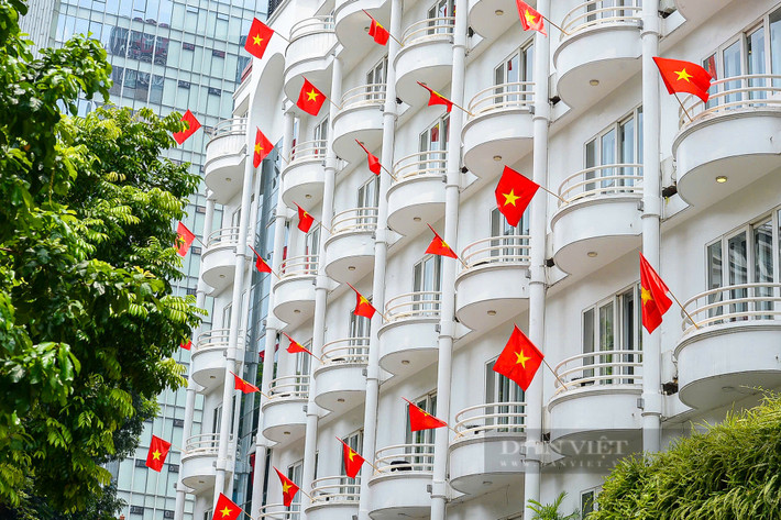 Một khách sạn nằm trên phố Tông Đản (quận Hoàn Kiếm) phủ sắc đỏ từ hàng chục lá cờ khổ lớn treo ở ban công tất cả các phòng. Những lá cờ Tổ quốc bay trong gió như gắn kết trái tim của hàng triệu người dân trong ngày lễ trọng đại. Ảnh: Khổng Chí.