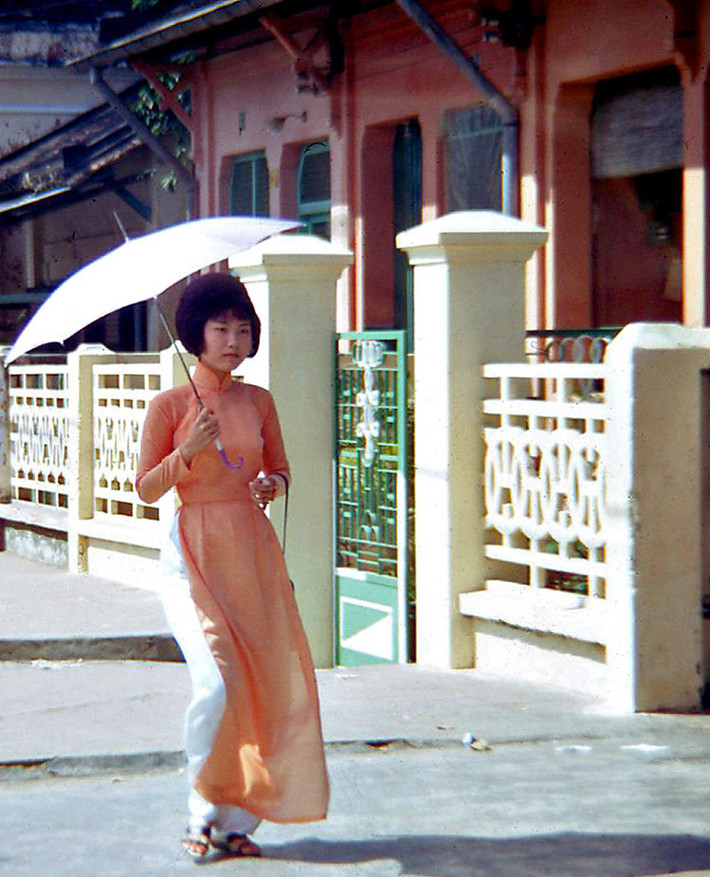Thiếu nữ áo dài che ô đi trên hè phố Phan Đình Phùng. Ảnh: Waynecam.