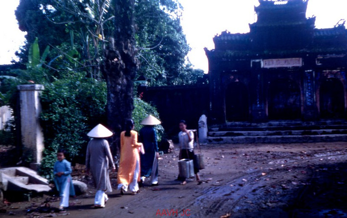 Người dân qua lại ở khu phố cổ Gia Hội. Phía xa là cổng tam quan của phủ Thọ Xuân Vương (Nguyễn Phúc Miên Định, con trai thứ ba của vua Minh Mạng).