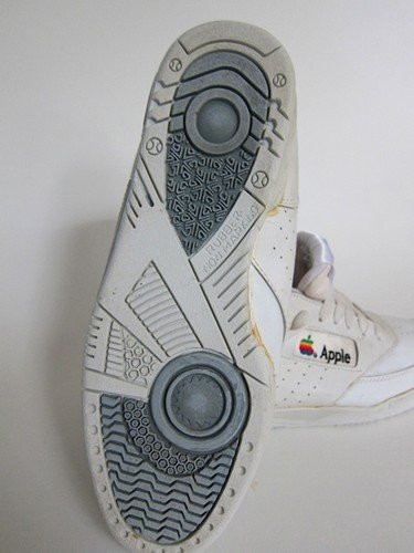 Đôi giày thoạt nhìn khá giống những mẫu cổ điển của Adidas với chất liệu da trắng, logo Apple 7 màu được in ở lưỡi, bên trong và ngoài thân giày. Đế giày được làm bằng cao su giúp chống trơn trượt. Chắc chắn đây là lần đầu tiên bạn biết đến sản phẩm của Apple này, thậm chí khi đã là "fan ruột" của Táo. Được biết, nó được bán cho 1 nhân viên của Apple vào giữa thập niên 90, sau đó được bán lại với giá 79 USD trên eBay vào năm 2007.