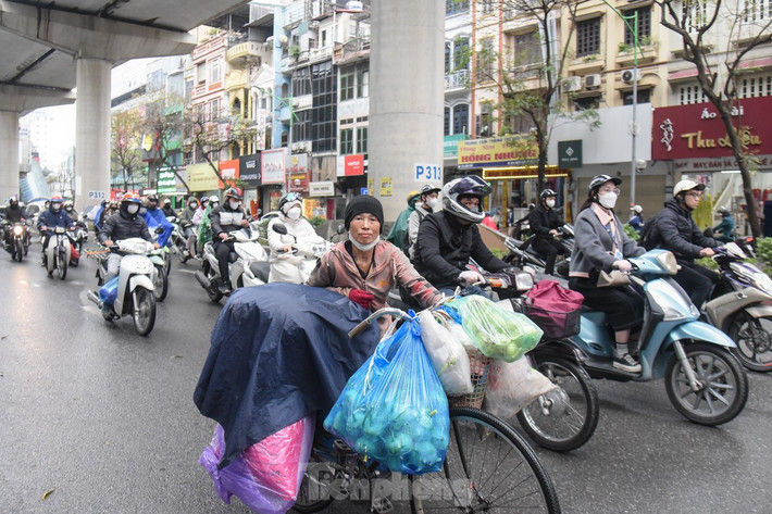 Thường ngày đi làm từ sáng sớm, nhưng hôm nay bà Hằng chờ tới 9 giờ sáng mới đẩy chiếc xe đạp cùng với đống hàng hoá, rau củ ra đường. "Sáng sớm trời rét buốt nên tôi đi bán hàng muộn hơn, trời mưa cũng không khách hàng", bà Hằng chia sẻ.