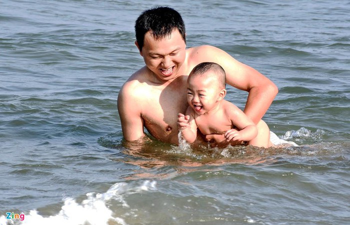 Anh Trương Ngọc Cường (ngụ huyện Tư Nghĩa, tỉnh Quảng Ngãi) vui đùa cùng con trai. "Chủ nhật ở nhà ngột ngạt, oi bức quá, gia đình tôi cùng bạn bè tập trung 10 người xuống biển chơi", anh Cường chia sẻ.