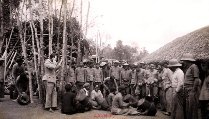 Binh lính và sĩ quan tụ họp xem các nhạc công chơi trống ở sân đồn.