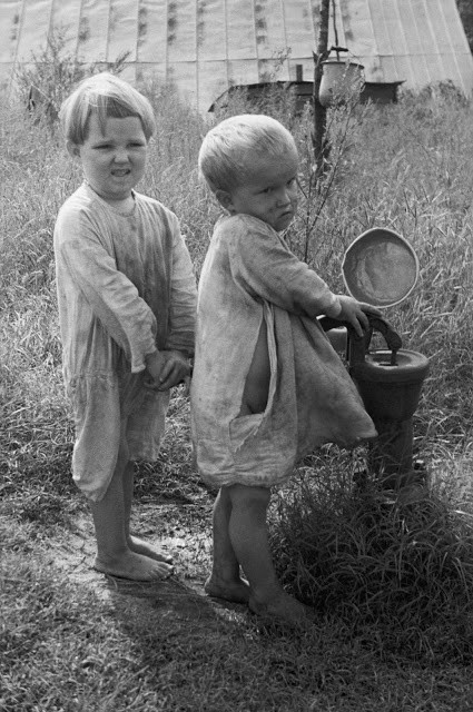 Hai em bé bên vòi bơm nước công cộng ở vùng nông thôn Bắc Carolina, 1935. Trong cuộc Đại suy thoái thập niên 1930, trẻ em là những đối tượng dễ bị tổn thương nhất. Ảnh: Arthur Rothstein.