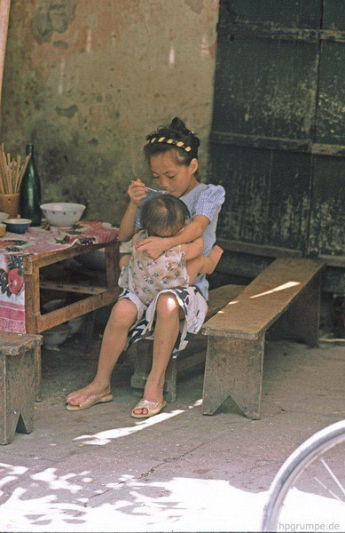 Phụ mẹ bón cho em ăn.