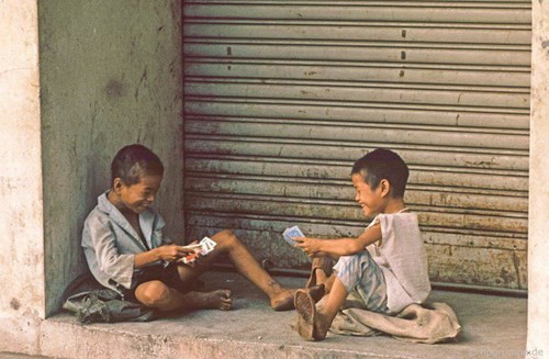 Hai trẻ bụi đời say sưa với trò tú lơ khơ.