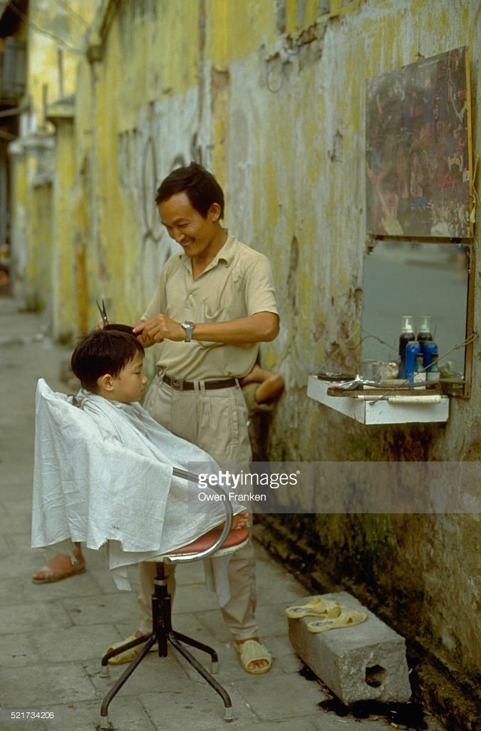 Một hiệu cắt tóc vỉa hè ở Hà Nội, Việt Nam thập niên 1990.