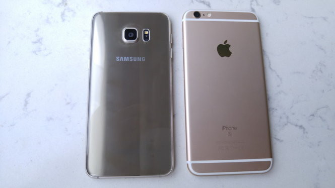 Mặt lưng Galaxy S6 Edge+ (trái) có kính cường lực với dòng chữ "Made in Vietnam by Samsung", pin 3000 mAh. iPhone 6S Plus mặt lưng kim loại có thêm chữ S, không khác biệt so với iPhone 6 Plus, pin 2750 mAh - Ảnh: Thanh Trực