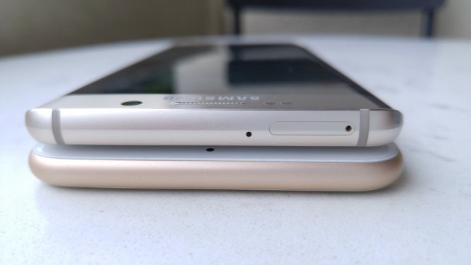 Khe SIM của Galaxy S6 Edge+ nằm ở cạnh trên thân máy, so với cạnh bên của khe SIM iPhone 6S Plus. Cả hai smartphone đều không có khe cắm thẻ nhớ micro-SD - Ảnh: Thanh Trực