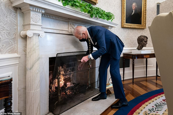 Tổng thống Joe Biden thêm củi vào lò sưởi trong Phòng Bầu dục ngày 22/1.