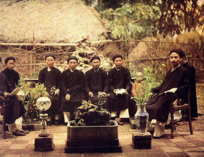 Các hương chức đọc sách, hút thuốc, thưởng hoa - những thú vui tao nhã của người Việt xưa - tại một vườn nhà ở ngoại thành Hà Nội khoảng năm 1920. Ảnh: Léon Busy.