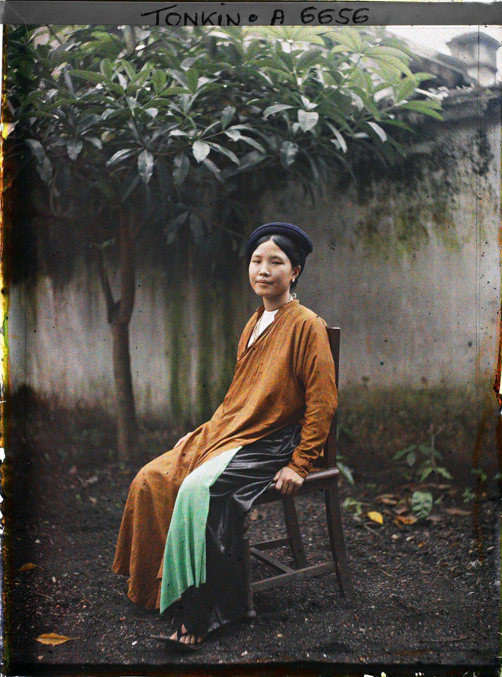 Tiểu thư Hà Nội ngồi trên ghế gỗ.