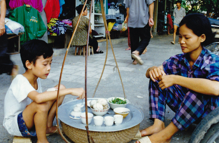Em bé được phục vụ tại gánh hàng trứng vịt lộn, một món ăn được báo chí quốc tế coi là "kinh dị" nhưng rất phổ biến ở Hà Nội. Ảnh: Bo Kage Carlson / Flickr.
