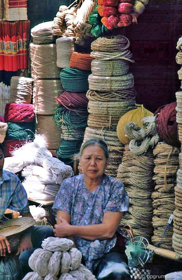 Cụ bà trông cửa hàng dây thừng.