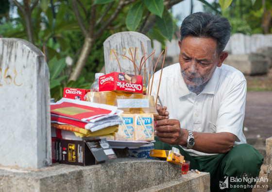 Giữa ngút ngàn hương khói ở Nghĩa trang Quốc tế Việt - Lào ở Anh Sơn, người cựu binh Trương Quang Liễu (xã Nghi Xuân, Nghi Lộc, Nghệ An) rưng rưng châm điếu thuốc cắm lên bình hương, rót chén rượu nồng mời người đồng đội từng được ông tự tay chôn cất ở chiến trường. Sau bao nhiêu năm qua đi, ông Liễu mới có thể tìm và thăm lại người đồng đội xưa nay đang nằm cùng gần 11.000 anh hùng liệt sĩ tại Nghĩa trang quốc tế Việt - Lào. Ảnh: Thành Cường