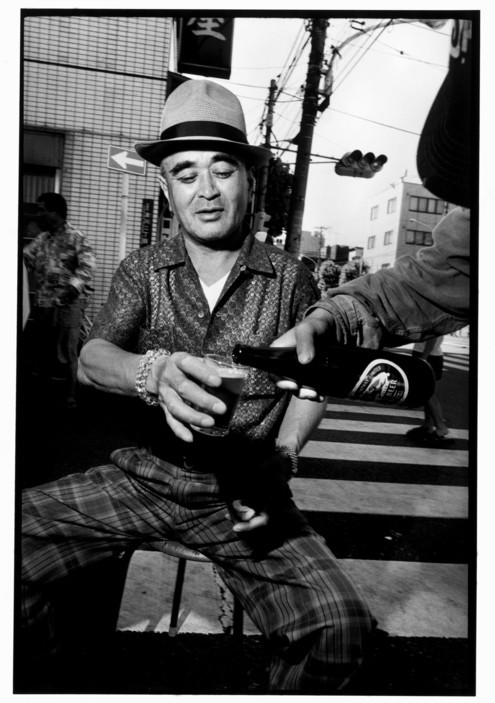 Thành viên Yakuza thưởng thức bia vào buổi sáng trên đường phố ở khu Sanya, Tokyo. Ảnh: Bruce Gilden/ Magnum Photos.