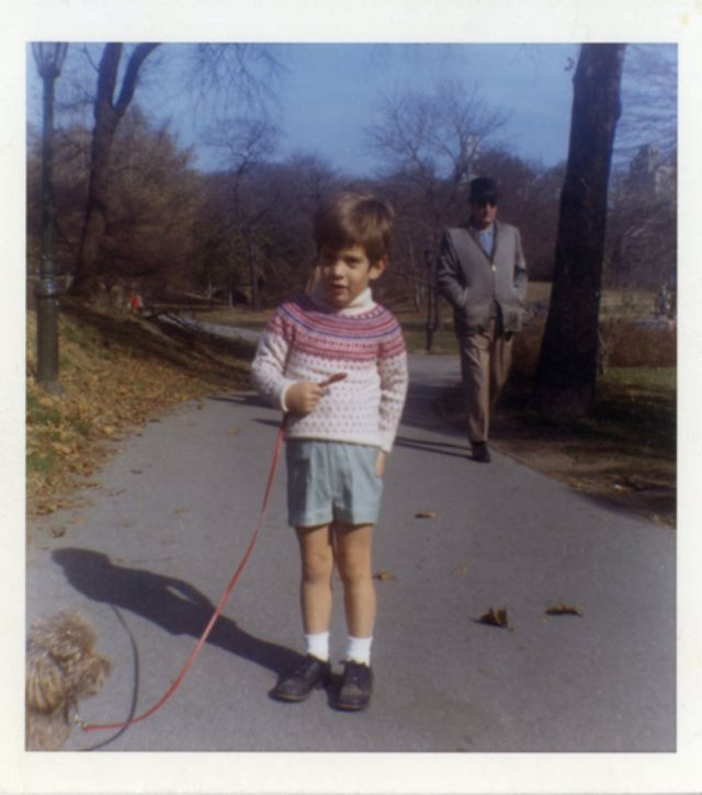 John F. Kennedy Jr. dắt chó đi dạo trong công viên, tháng 12/1964, hơn một năm sau khi Tổng thống Kennedy bị ám sát.