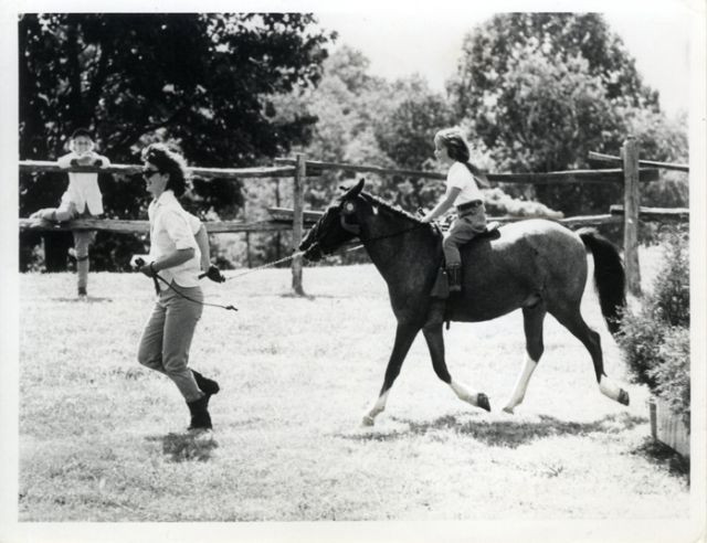 Đệ nhất phu nhân Jackie Kennedy dắt chú ngựa Macaroni cùng Caroline Kennedy cưỡi phía trên ở Wexford, Virginia.