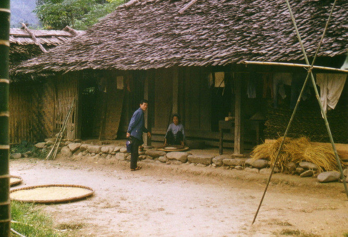 Cụ bà sàng gạo bên hiên nhà.