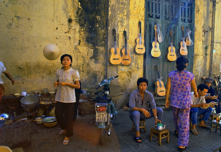 Một quán cà phê nằm cùng địa điểm với quầy bán đàn ghi-ta vỉa hè, vô tình tạo nên một không gian đậm chất "lãng tử" vào năm 1989. Chiếc xe Honda Cub ở giữa là niềm mơ ước của tất cả các đấng mày râu Việt Nam thời điểm này.