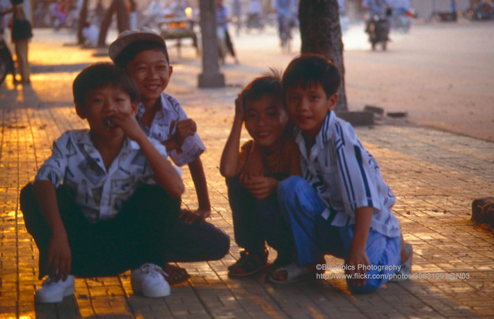 Bốn cậu bé tạo dáng trên vỉa hè.