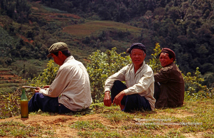 Ba người đàn ông ngồi trên đồi cùng chai rượu.