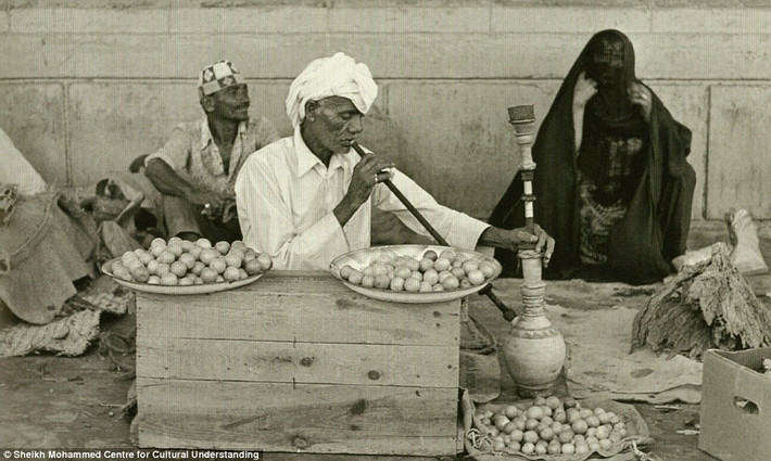 Người đàn ông tranh thủ hút shisha khi ngồi bán chanh ngoài chợ.