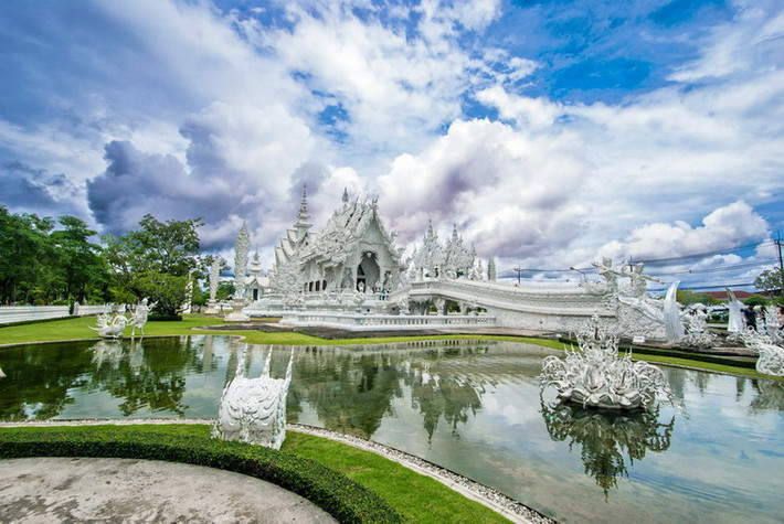 Bao quanh ngôi chính điện là các hồ cá nằm giữa thảm cỏ xanh, nơi đặt những tác phẩm điêu khắc được chính họa sĩ Chalermchai thiết kế.