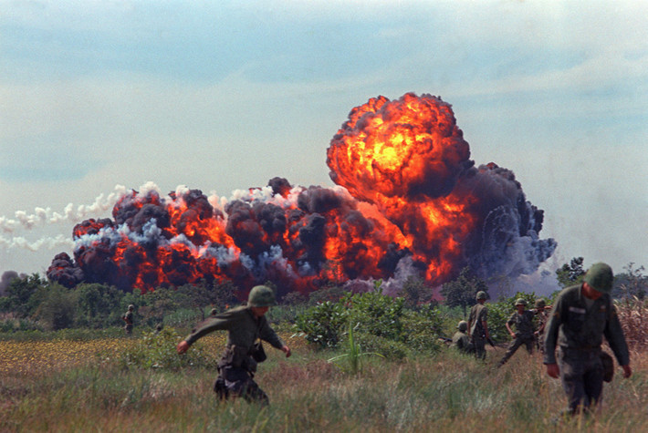 Bom napalm của Mỹ phát nổ và tạo ra quầng lửa lớn ngay gần các binh sĩ của quân đội Mỹ đang tuần tra tại miền Nam Việt Nam năm 1966. Ảnh: AP.