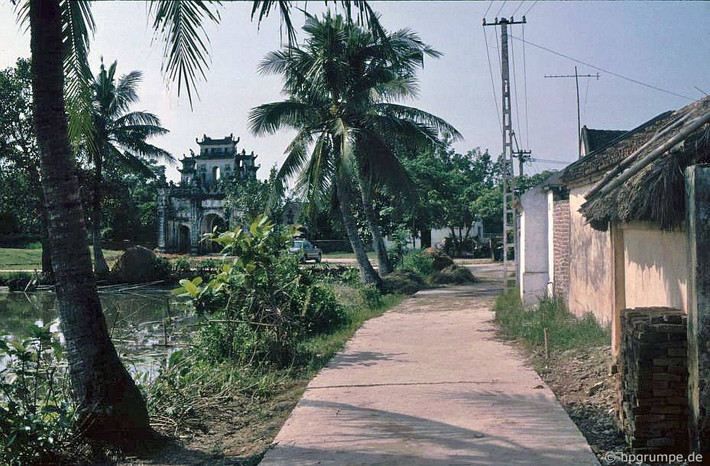 Trên một con đường của làng rắn Lệ Mật năm 1991. Phía xa là cổng đình Lệ Mật.
