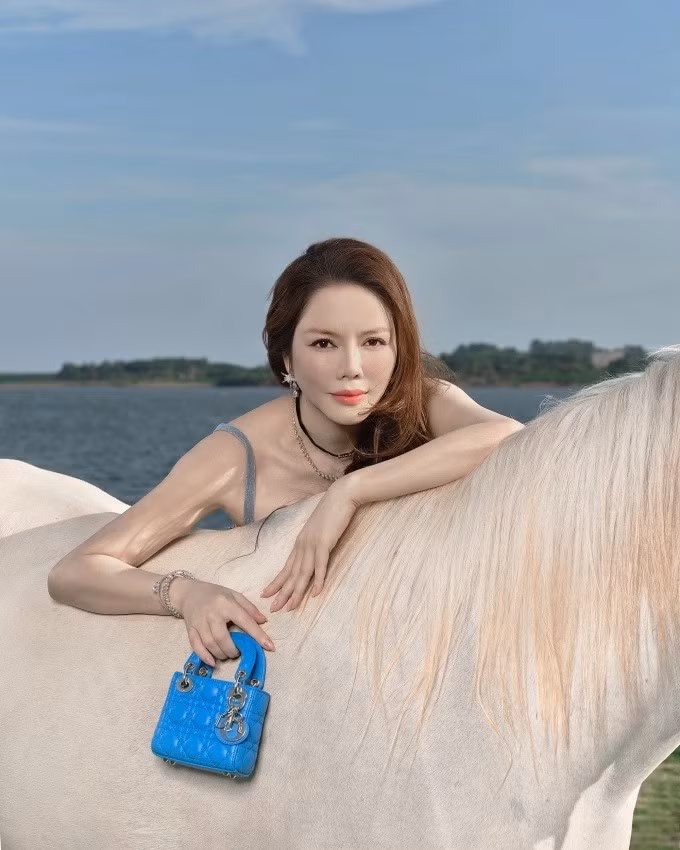 Trong khung cảnh sông nước hiền hòa, hàng cây xanh mướt và ánh nắng đầu xuân, Lý Nhã Kỳ xuất hiện với thần thái điềm tĩnh, tự tin, toát lên vẻ đẹp của một người phụ nữ từng trải, độc lập và làm chủ cuộc sống.