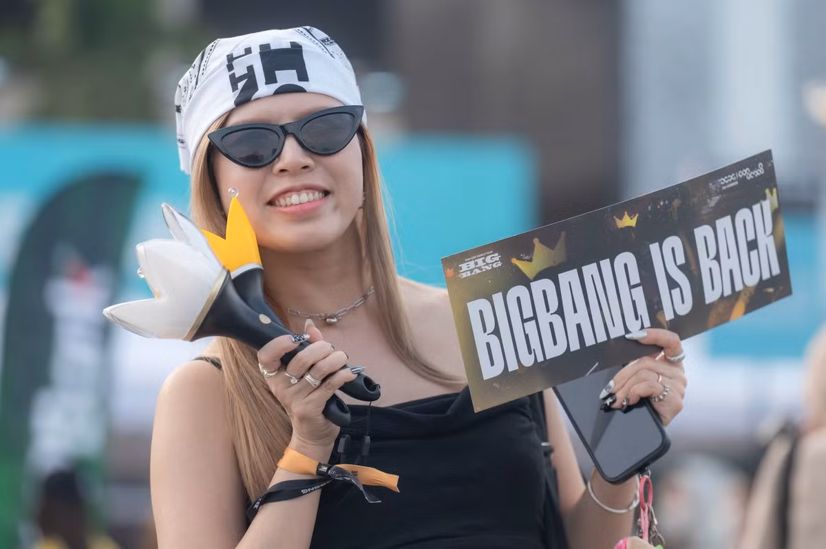 Trước đó, trong hai ngày 22-23/10, hàng dài người hâm mộ đã có mặt tại Mỹ Đình để đổi vòng tay, chuẩn bị cho concert. Bên cạnh việc xếp hàng, khu vực gian hàng và photobooth cũng là điểm đến của khán giả. Nhiều người chuẩn bị lightstick hình vương miện, biểu tượng đặc trưng của cộng đồng V.I.P (PV: Tên cộng đồng fan BigBang). Dịp này, ban tổ chức còn giới thiệu gần 70 dòng sản phẩm lưu niệm chính hãng, trong đó có lightstick phiên bản kỷ niệm 20 năm và áo thun được thiết kế riêng cho chặng Hà Nội.