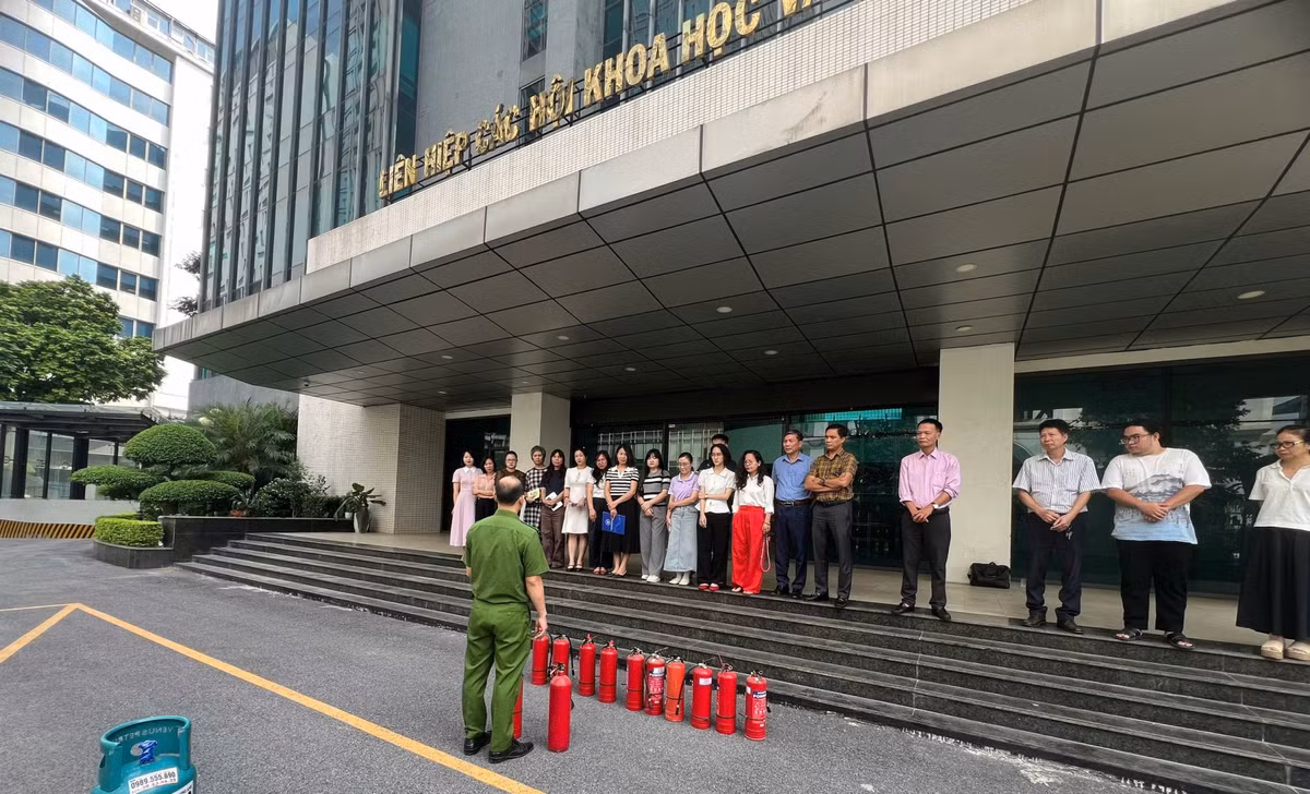 Thiếu tá Vương Văn Khôi hướng dẫn cán bộ, nhân viên tòa nhà thực hành sử dụng bình chữa cháy